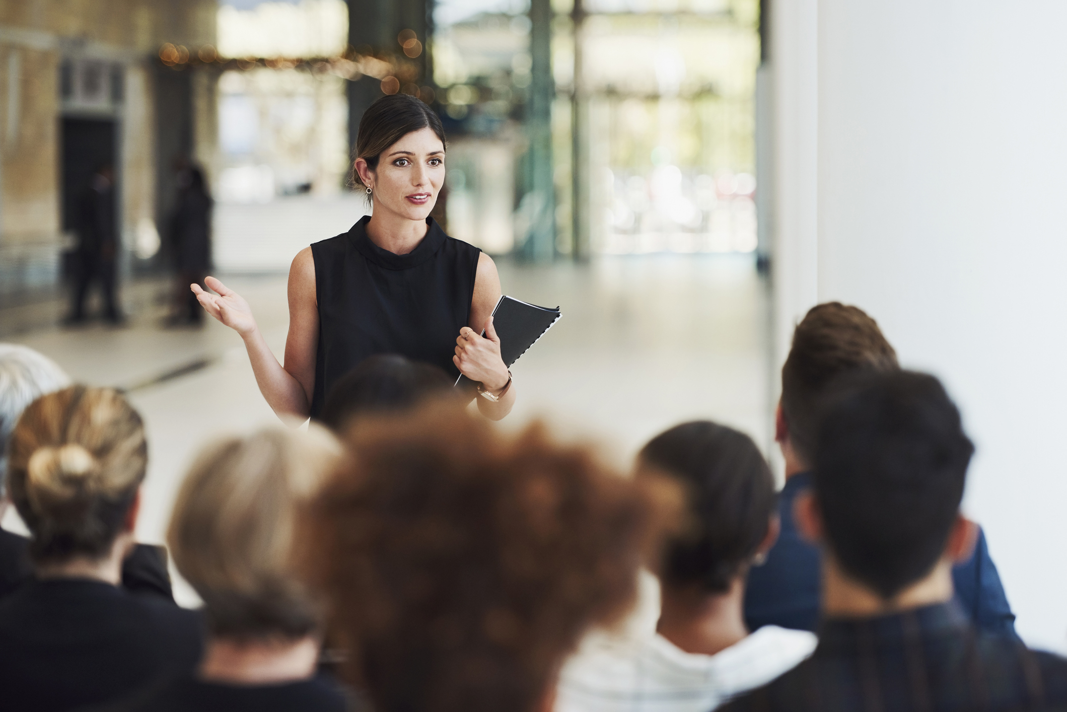 Female consultant giving a presentation to a room full of employees.