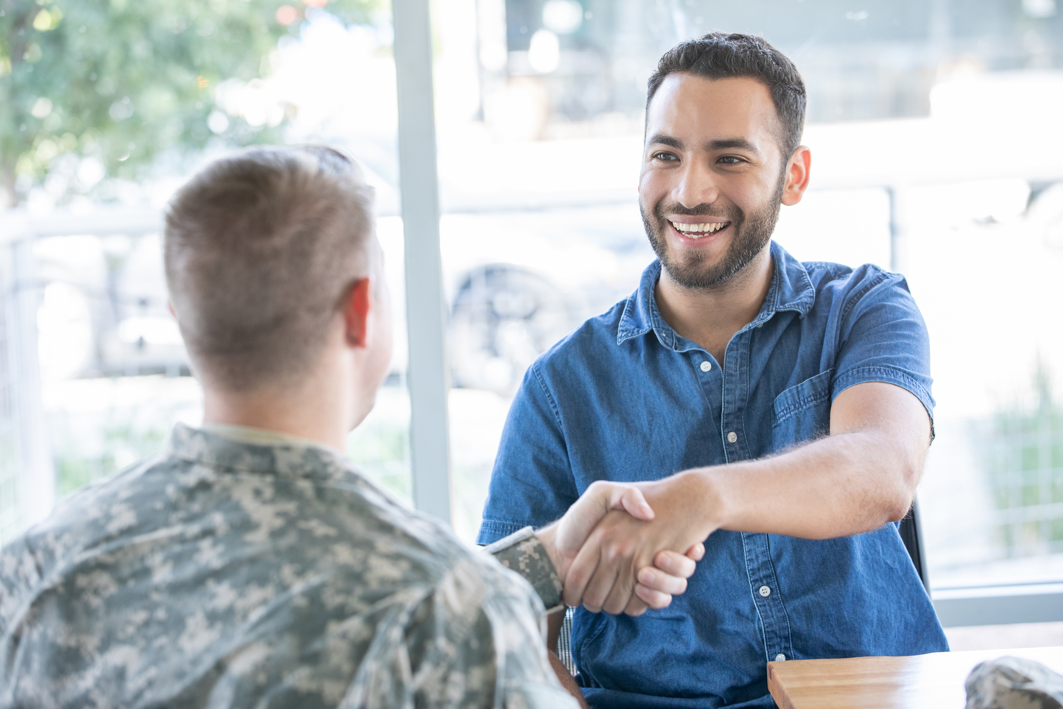 Man shaking hands with military man