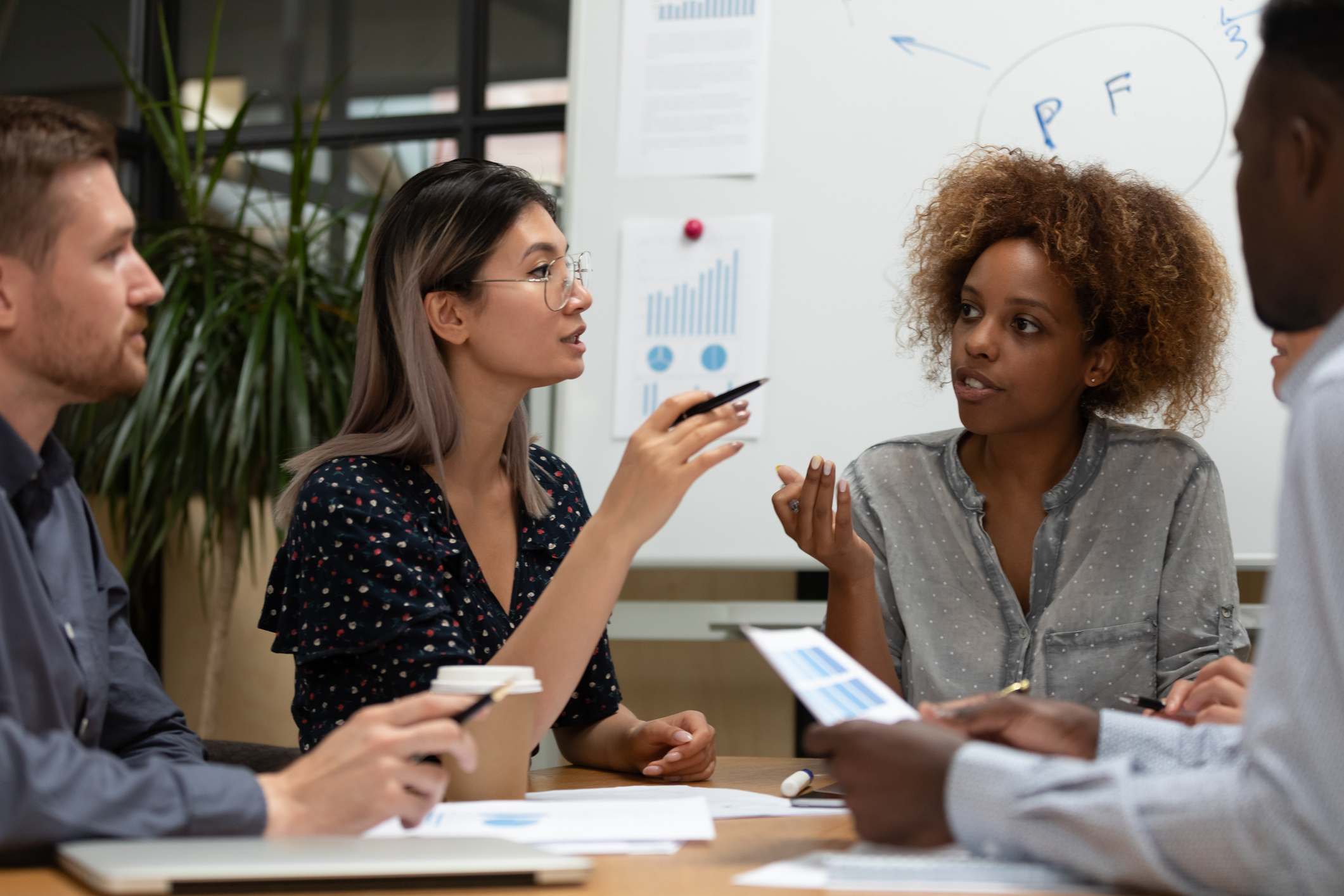 Colleagues seated around a table sharing project ideas