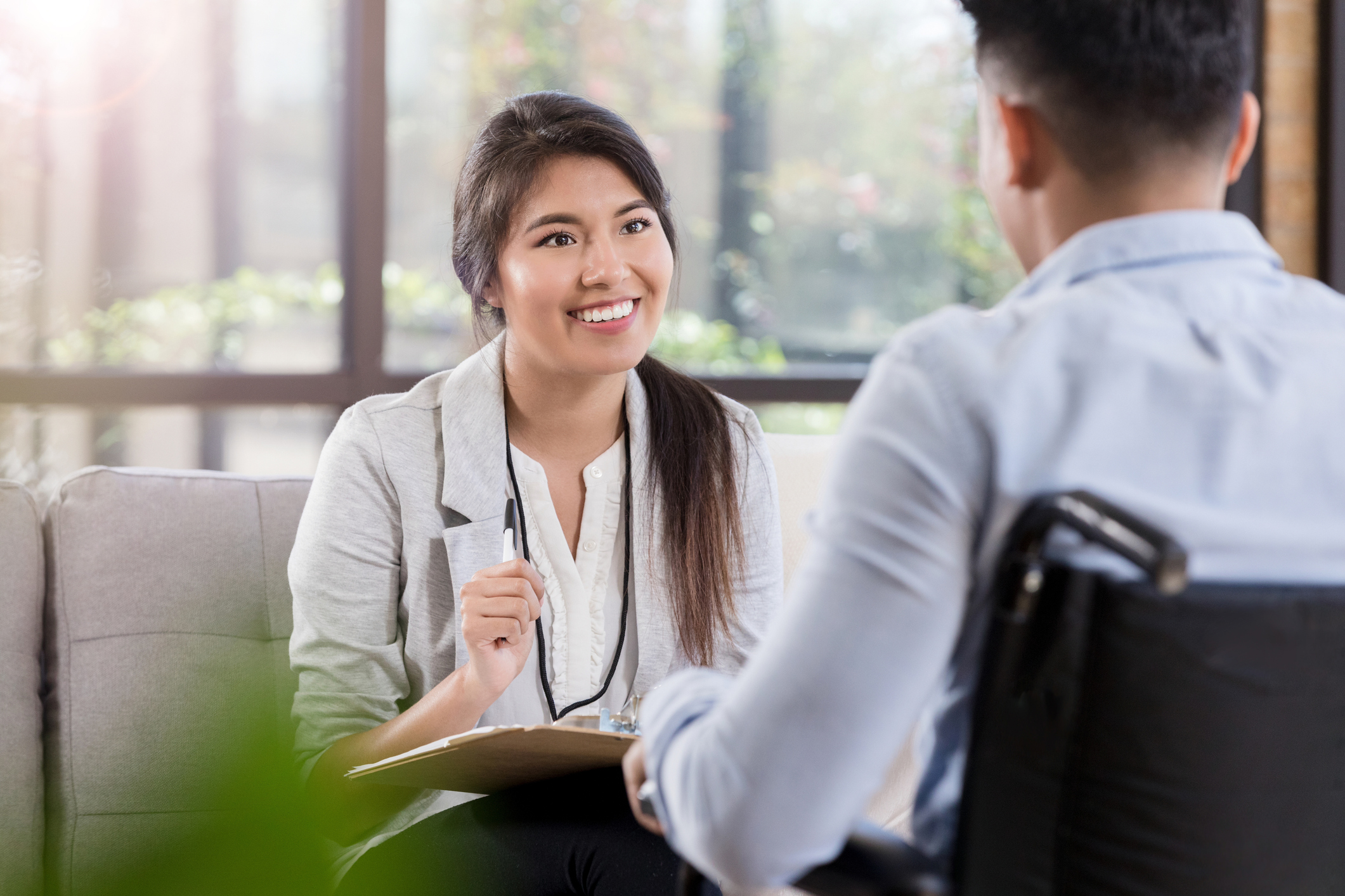 Female employee talking with male employee in a wheelchair.