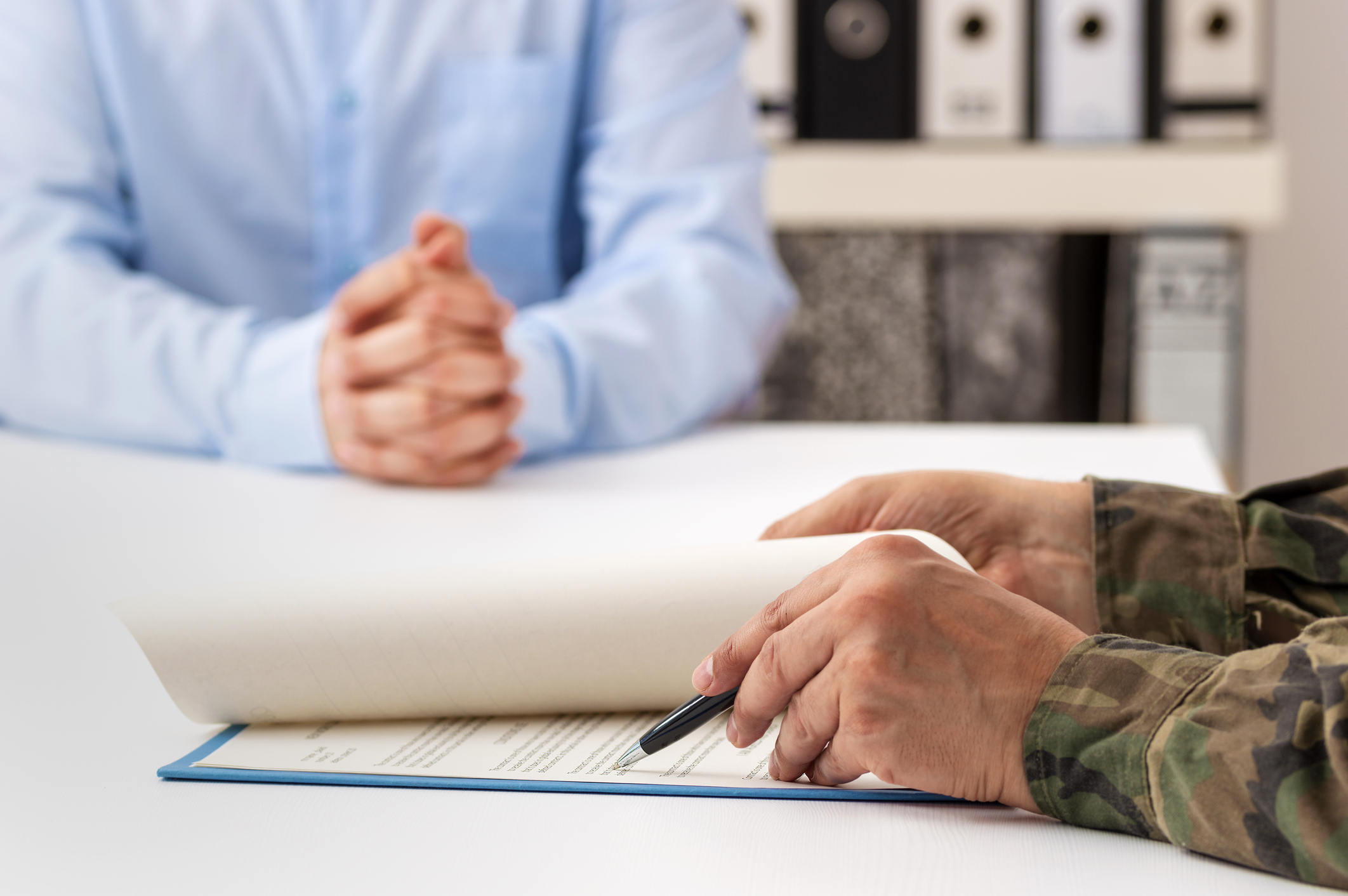 Man and military man completing paperwork together at a desk