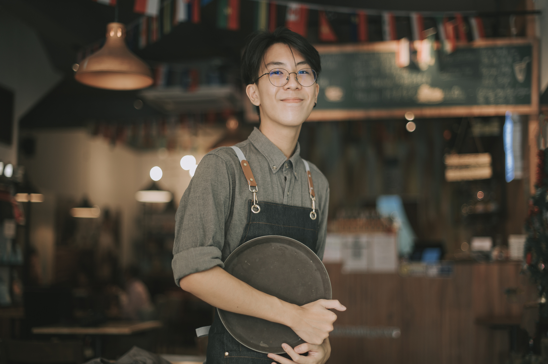 Teenage waiter at work smiling at camera