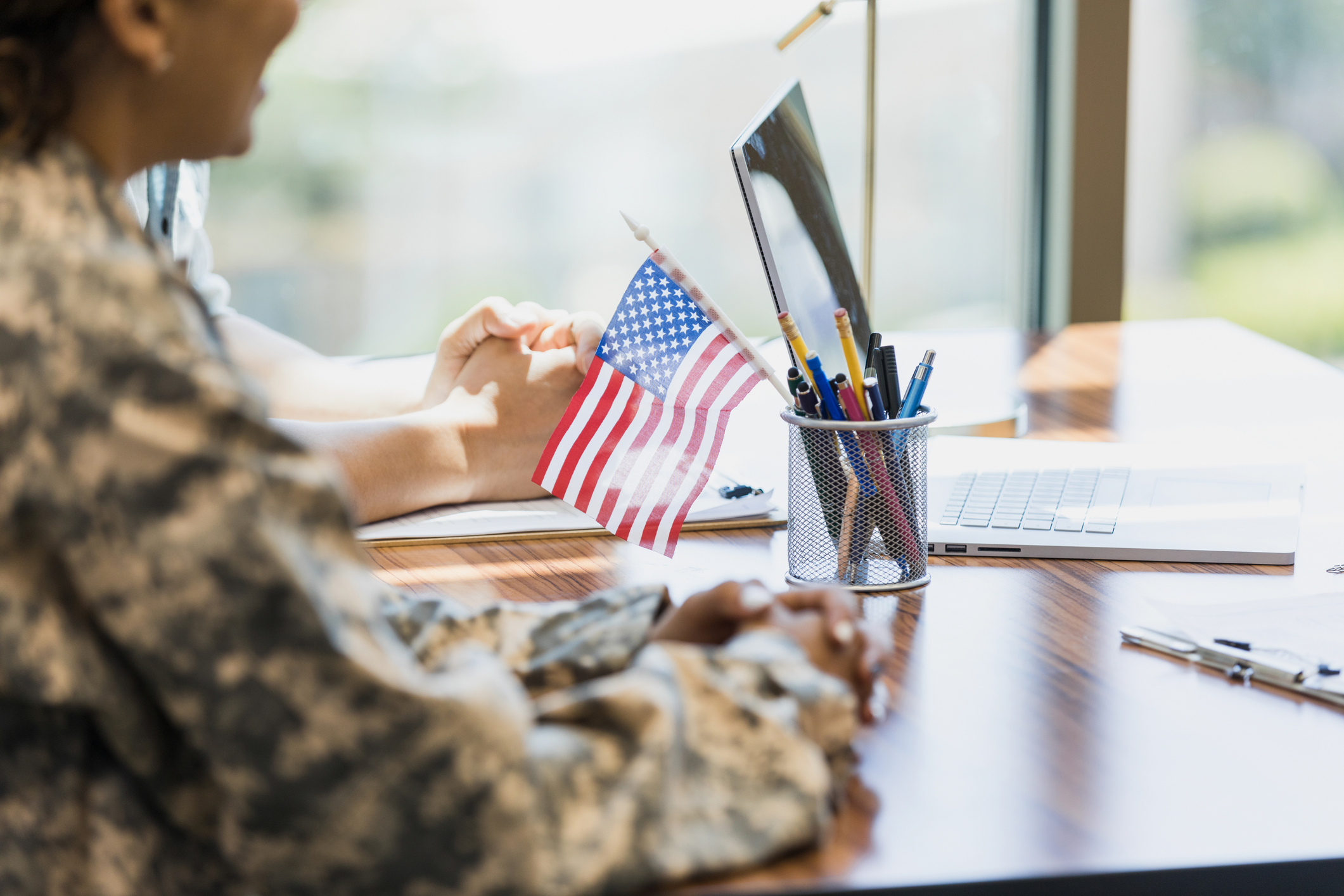 Military woman waiting with hands on a desk